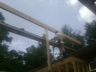 Carpenter setting a ridge beam over a new addition frame — Ice Dam Removal by Roofing Brothers in Kelley