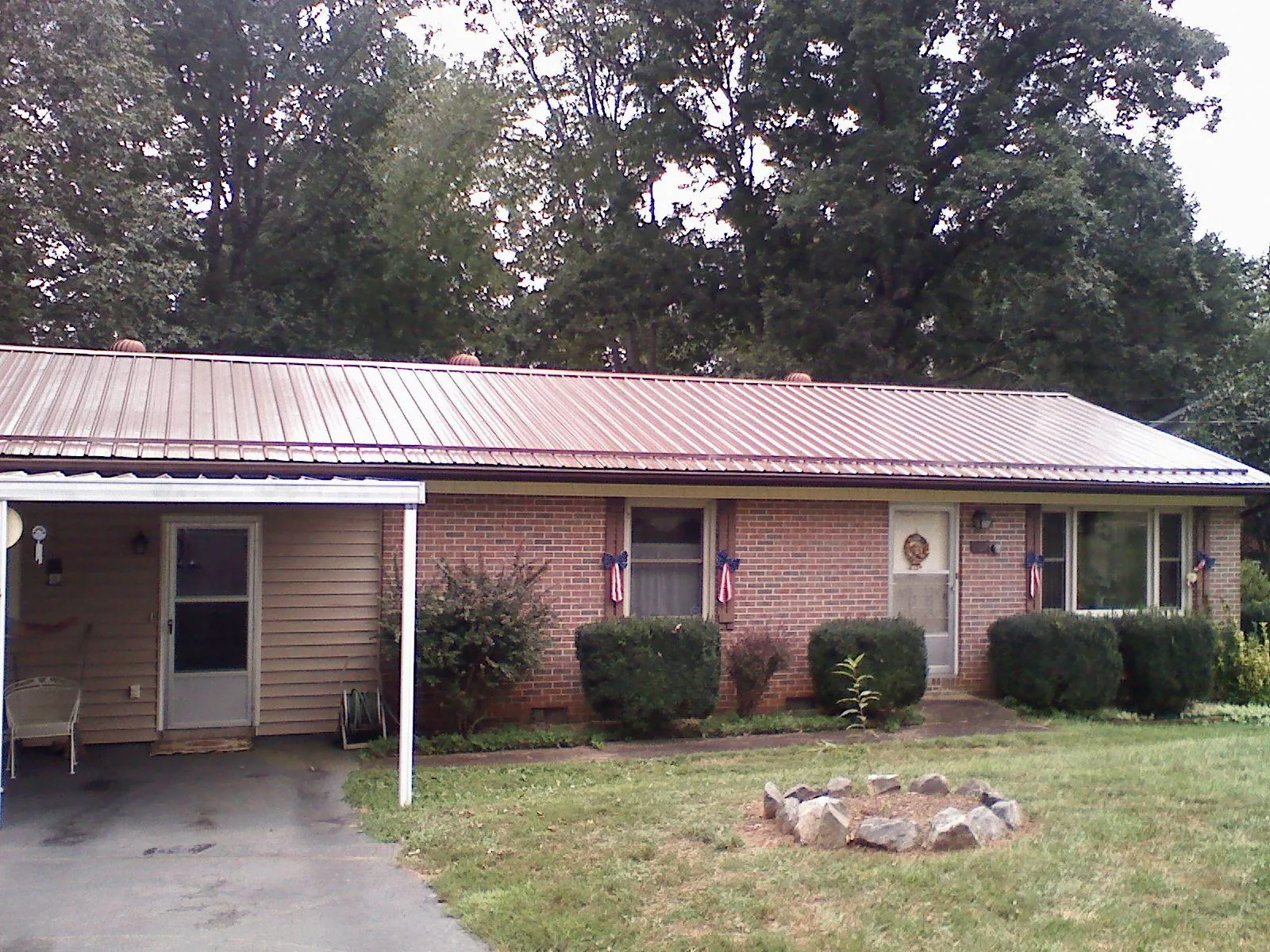 Bronze metal roof and carport on a brick ranch home — Roof Repair work by our crew in Kelley